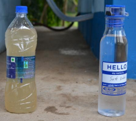 A bottle of dirty water and a bottle of water purified by Global Water Consortium.