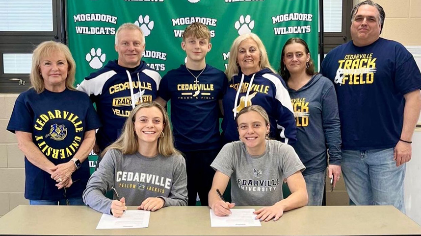 Julie and Ari Tompkins with their family as they sign to run track at Cedarville University.