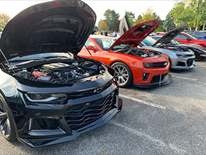 Muscle cars with open hoods at ICC car show.