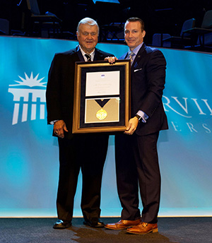 Dr. Thomas White presenting Lorne Scharnberg with the Cedarville University Medal of Honor.