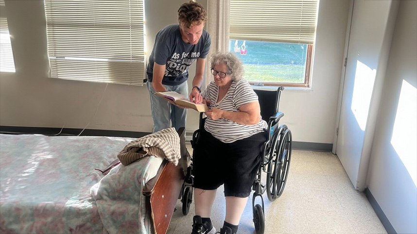 Cedarville student reads Scripture with nursing home resident.