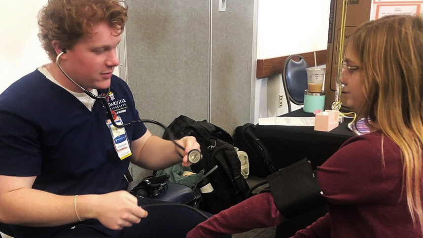 Nursing student takes child's blood pressure.