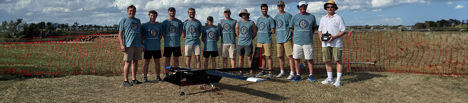 Students and professors on the AERO design team pose with their plane alongside the airstrip in Florida.