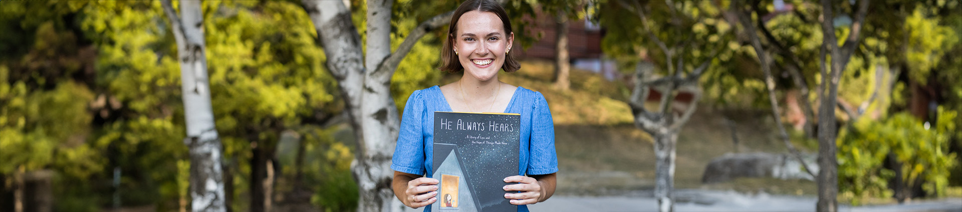 Alyson Punzi holds her children's book "He Always Hears."