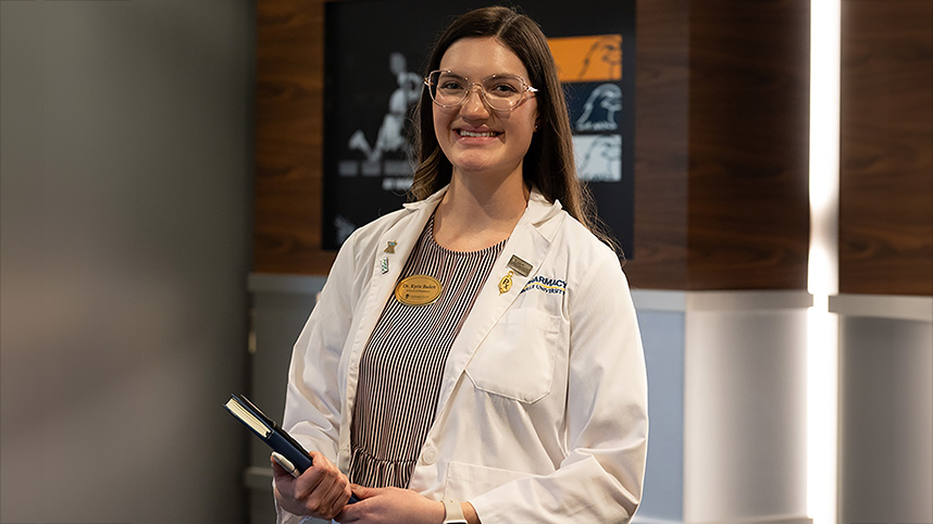Dr. Kyrie Baden in a white pharmacist's coat.