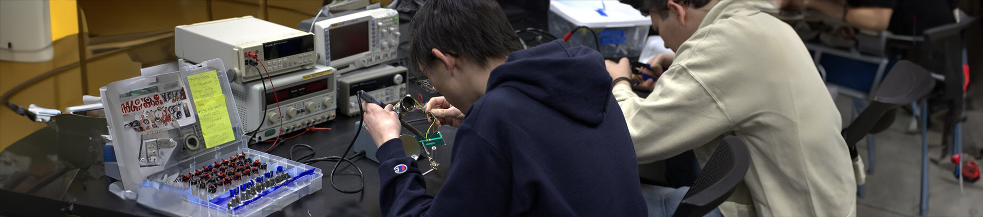 Two students building solar lights in an engineering lab.