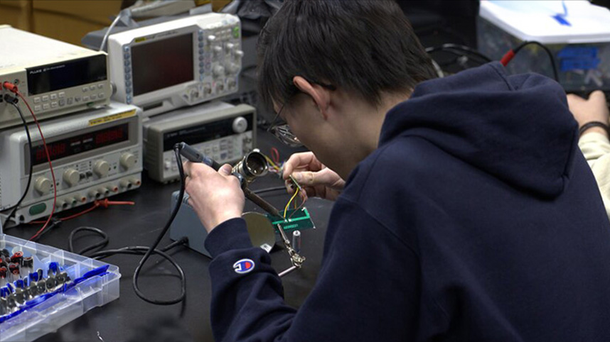 Two students building solar lights in an engineering lab.
