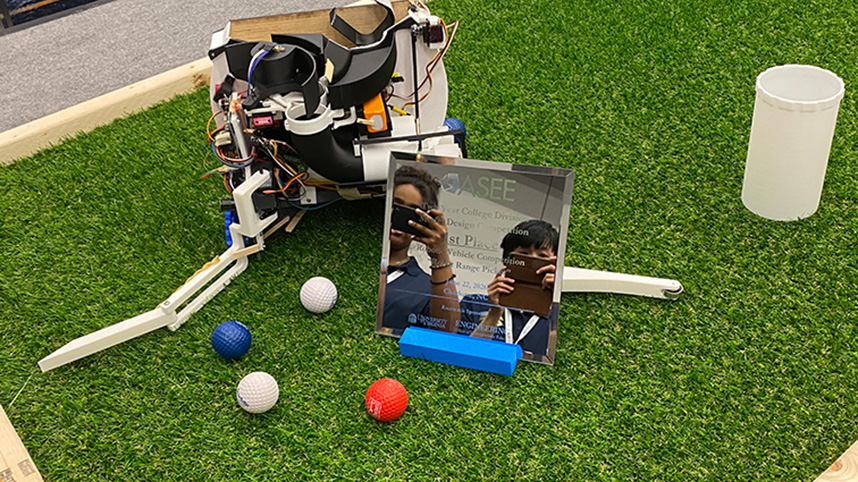 The Cedar Gleaner robot picking up golf balls on a green turf course.