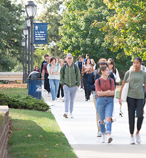 Students walking across campus on a summer day.