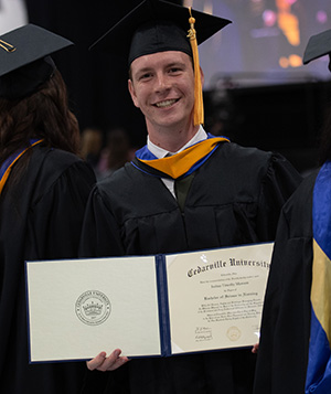 A Cedarville graduate smiles for the camera.