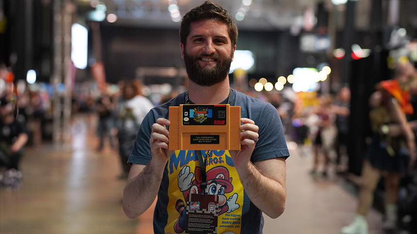 Dan Jewett holds up a video game cartridge.