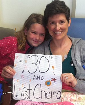 A young Taylor DeYoung poses for a photo with her mother during her mother's 30th chemo treatment.
