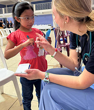 A young girl interacts with a nurse at a medical missions clinic.