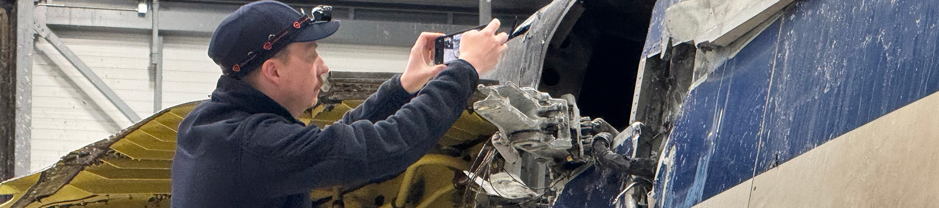 Caleb Wagner inspecting the wreckage of a plane.