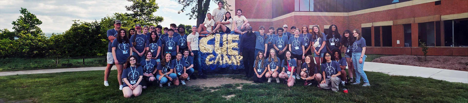 Cue camp participants pose for a picture at "the rock" on Cedarville University's campus.