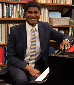 Dr. Lou Lilite seated at the piano in his office.