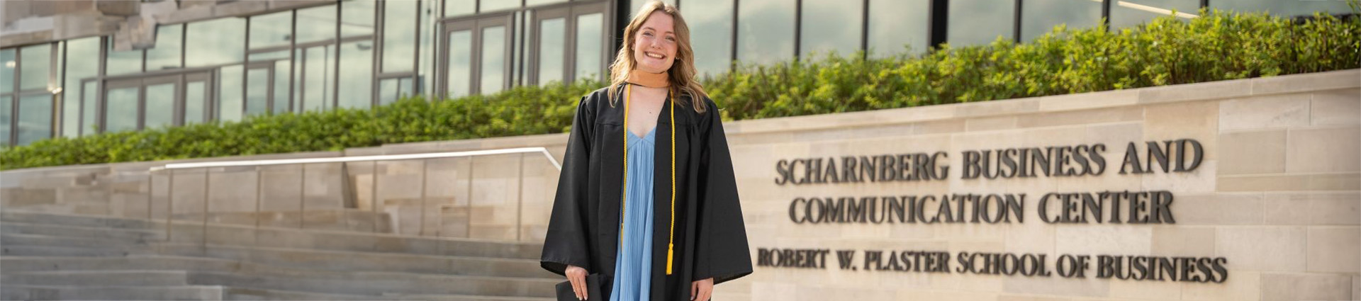 Elizabeth Dunham in her graduation robe outside the Scharnberg Business and Communication Center on the campus of Cedarville University.