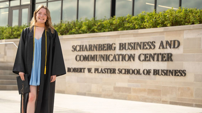 Elizabeth Dunham in her graduation robe outside the Scharnberg Business and Communication Center on the campus of Cedarville University.