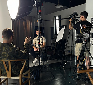 Ohio State University football player sitting for an interview in a filming studio.