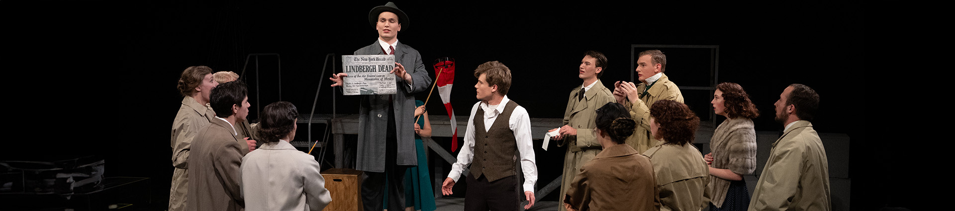 Students dressed as 1920s reporters surround an actor protraying the young Charles Lindbergh.