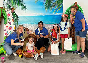 Joni and Friends volunteers pose for a beach photo with smiling children.