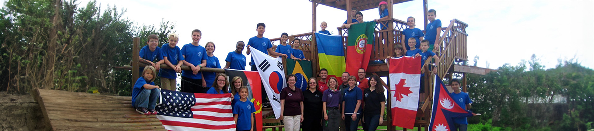 Students at the Greater Lisbon Christian Academy hold up flags from their home countries on the playground.