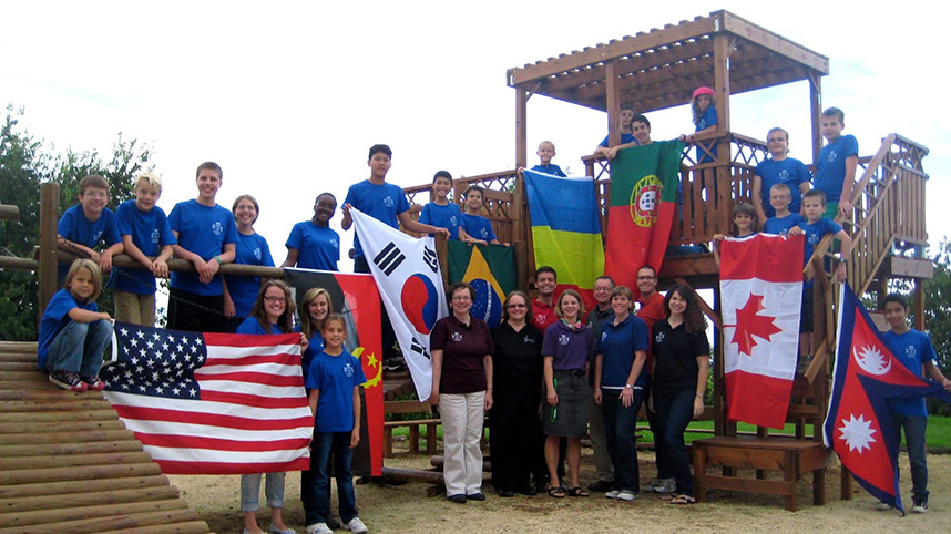 Students at the Greater Lisbon Christian Academy hold up flags from their home countries on the playground.