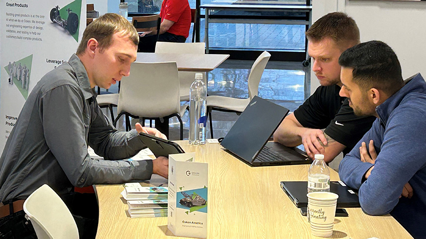 Two students discuss potential careers with a company representative at the ICC recruitment day.