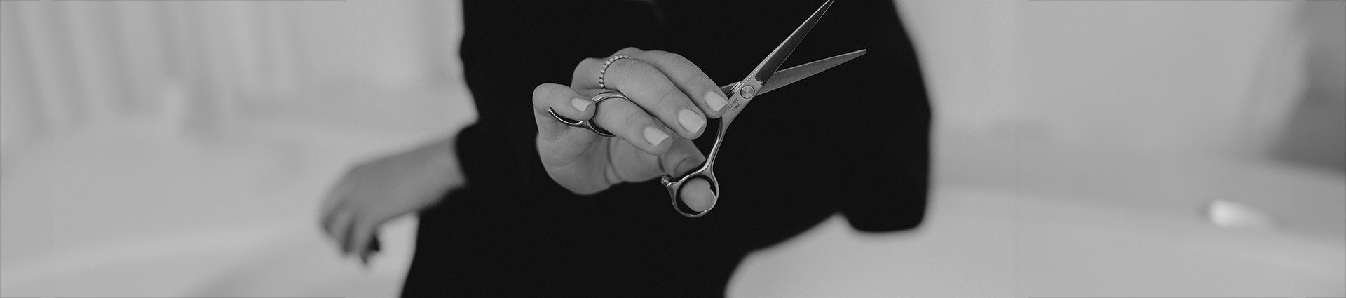 Close up image of a hand holding hair cutting shears.