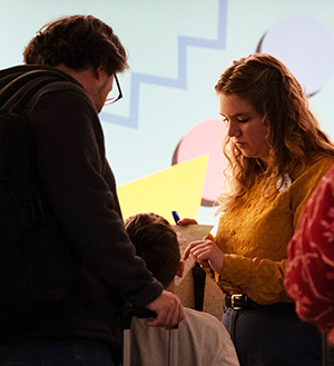 Abigail Foster helps a man and his daughter in the lobby of Pop Century Resort.