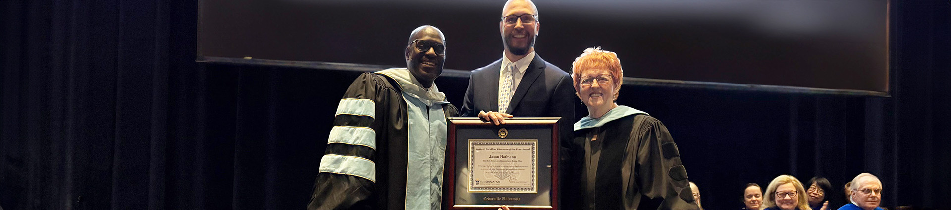 Jason Hofmann receives Excellent Educator of the Year award from Dr. Kevin Jones and Dr. Brenda MacKay.