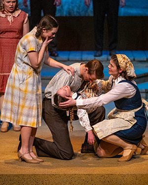 Actors and actresses in 1930s era dustbowl era costumes lament the loss of a child.
