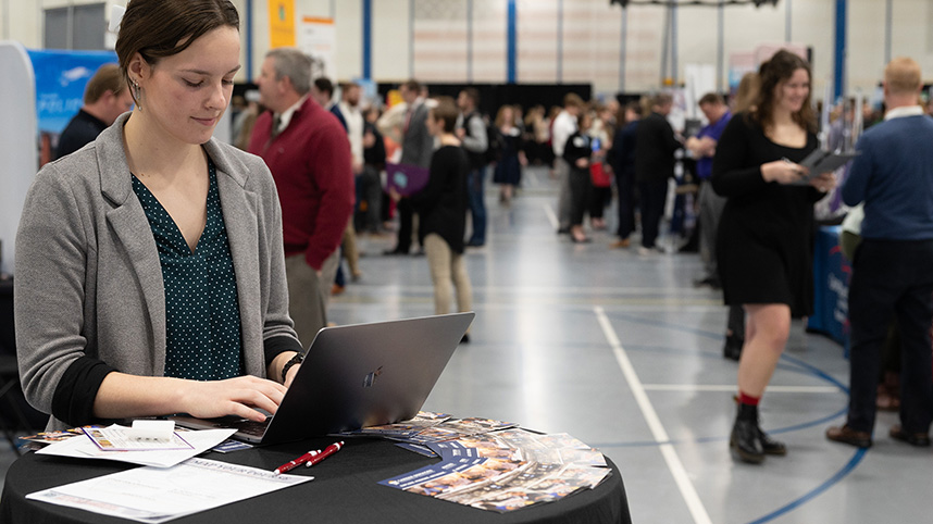 A female student takes notes on her computer at the Cedarville University career fair.