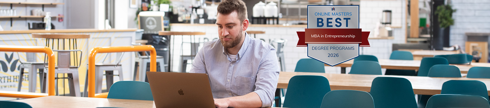 Man working at a computer with Best MBA in Innovation badge beside him on the image.