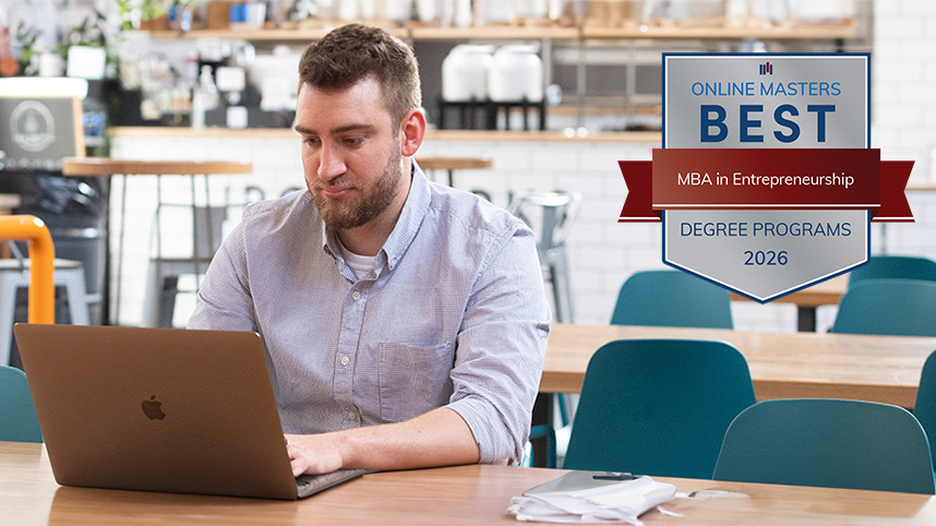 Man working at a computer with Best MBA in Innovation badge beside him on the image.