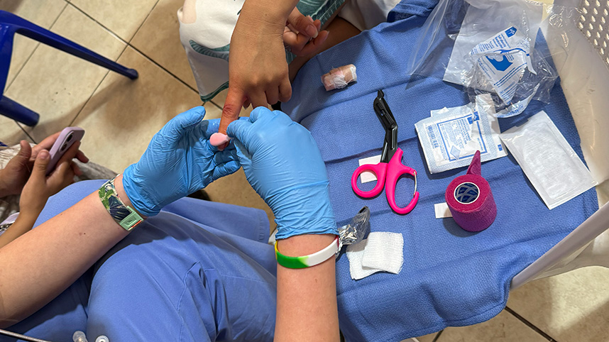 A nurse treats a child's hand.