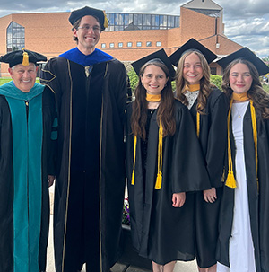 Erin Mitchell with other Cedarville graduates and a professor.
