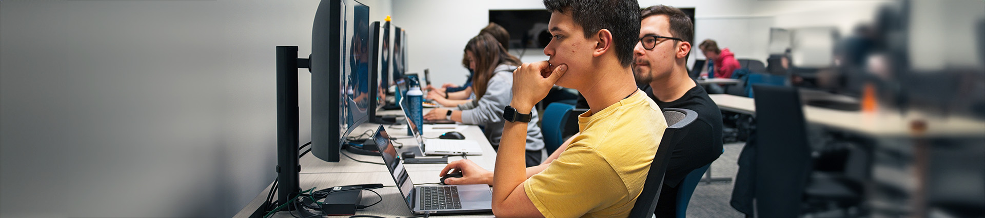 Students seated at computers compete in the National Cyber League Competition.