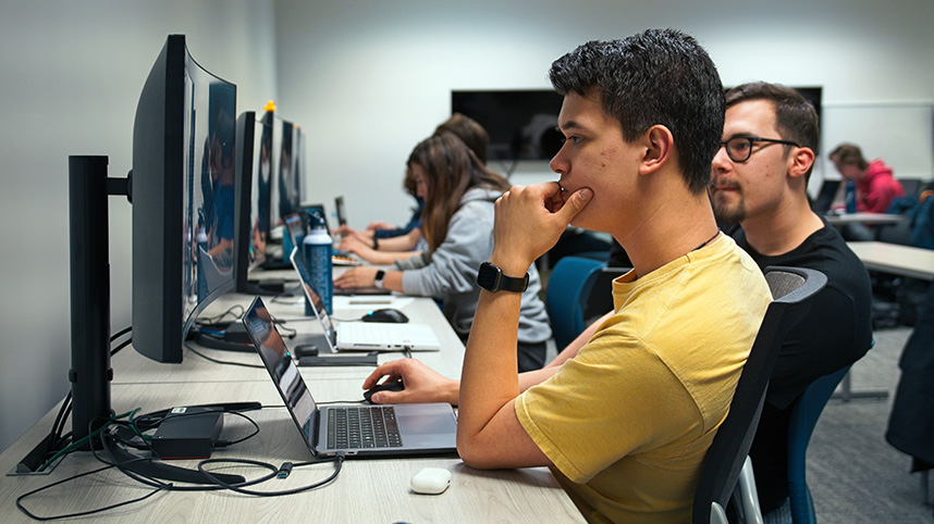 Students seated at computers compete in the National Cyber League Competition.