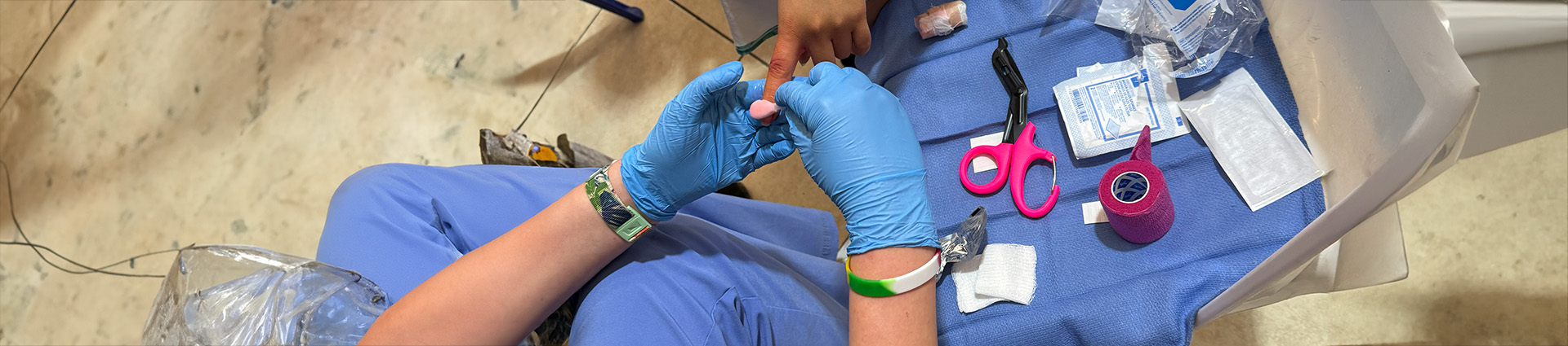 Nurse bandaging a child's finger.