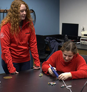 Abigail Nutter gives another studnet instructions as the student assembles a solar light.