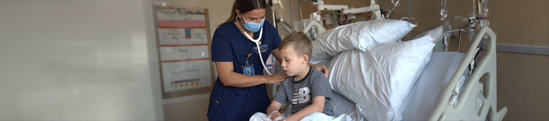 Nurse listens to little boy's heart and lungs.