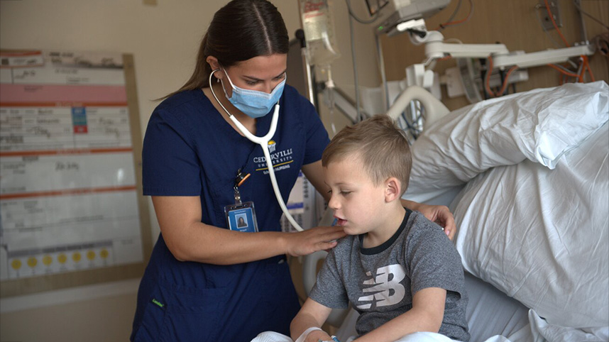 Nurse listens to little boy's heart and lungs.