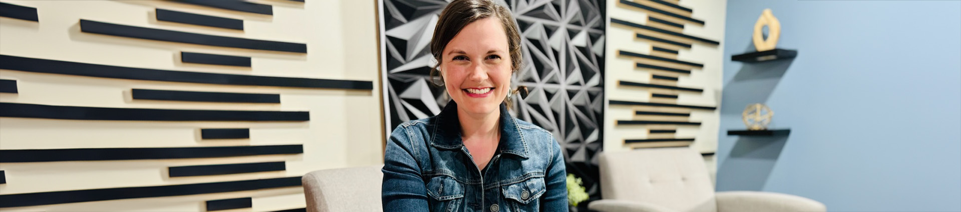 Renee Leanne sitting in blue and cream contemporary room.