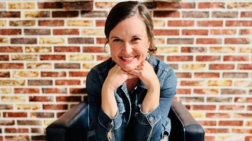 Renee Sallee sits in front of a brick wall.