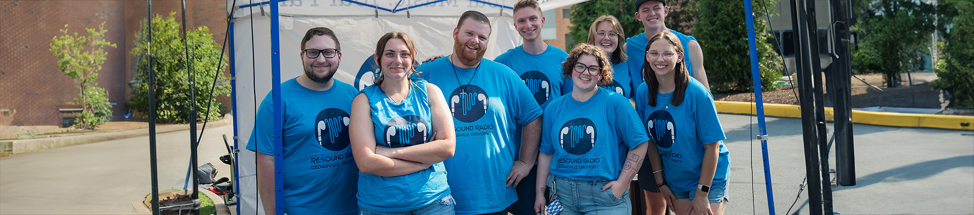 Students in Resound Radio t-shirts play music during a campus event.