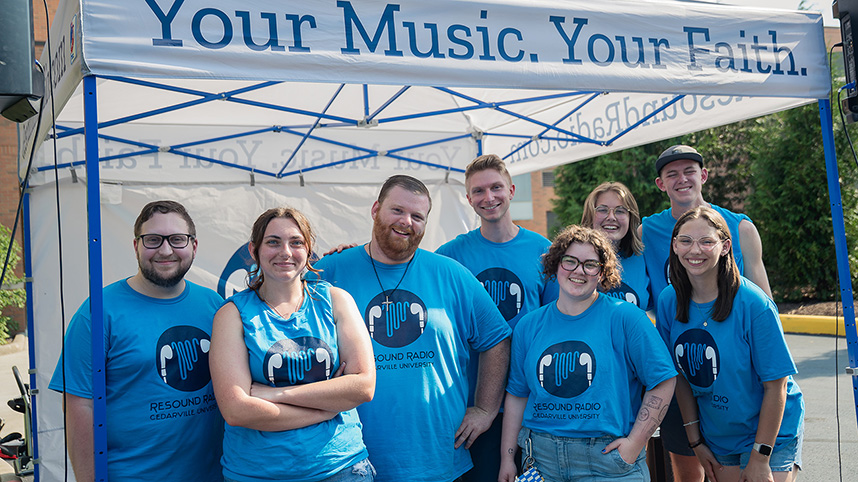 Students in Resound Radio t-shirts play music during a campus event.