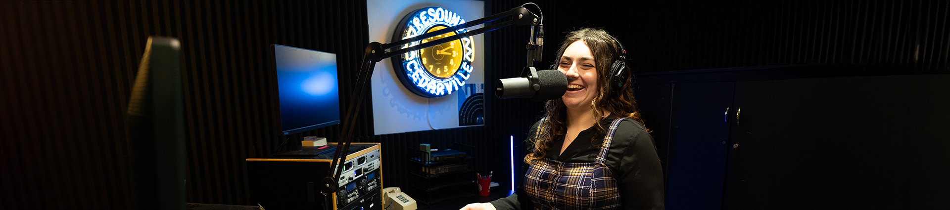 A female student speaking into the microphone in the Resound Radio studio.