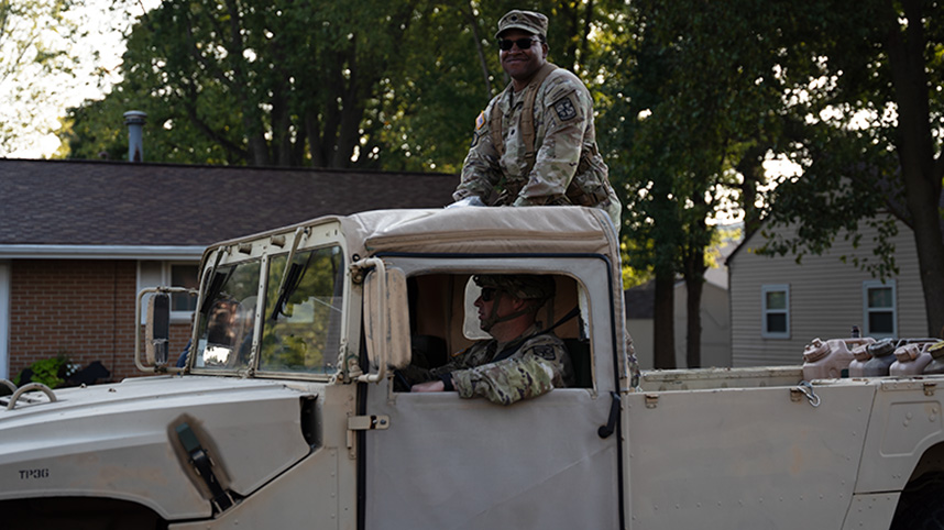 Uniformed Cedarville ROTC unit standing in the back of a military truck.