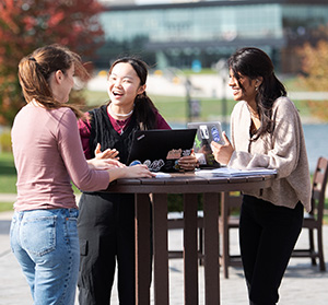 Three female students enjoy a beautiful day on Cedarville's campus.